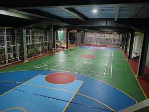 Lapangan multifungsi indoor dengan pencahayaan dan flooring olahraga